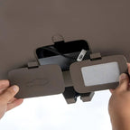 Brown leather car sun visor organizer with integrated storage compartment and white mesh pocket.