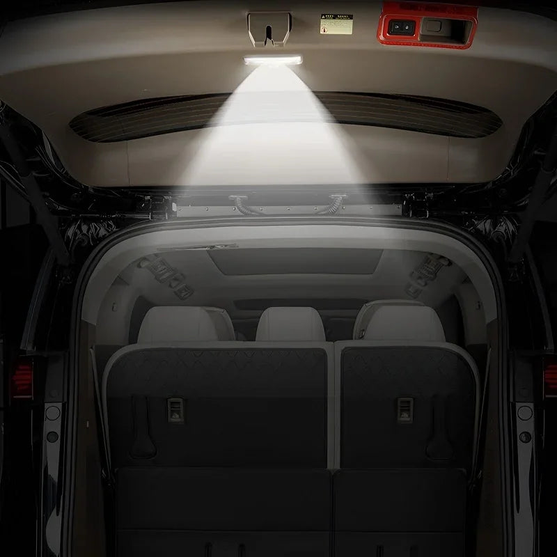 Bright LED interior trunk light illuminating the dark cargo area of a black SUV.