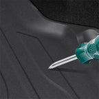 Durable black textured rubber car floor mat being tested for scratch resistance with a screwdriver.