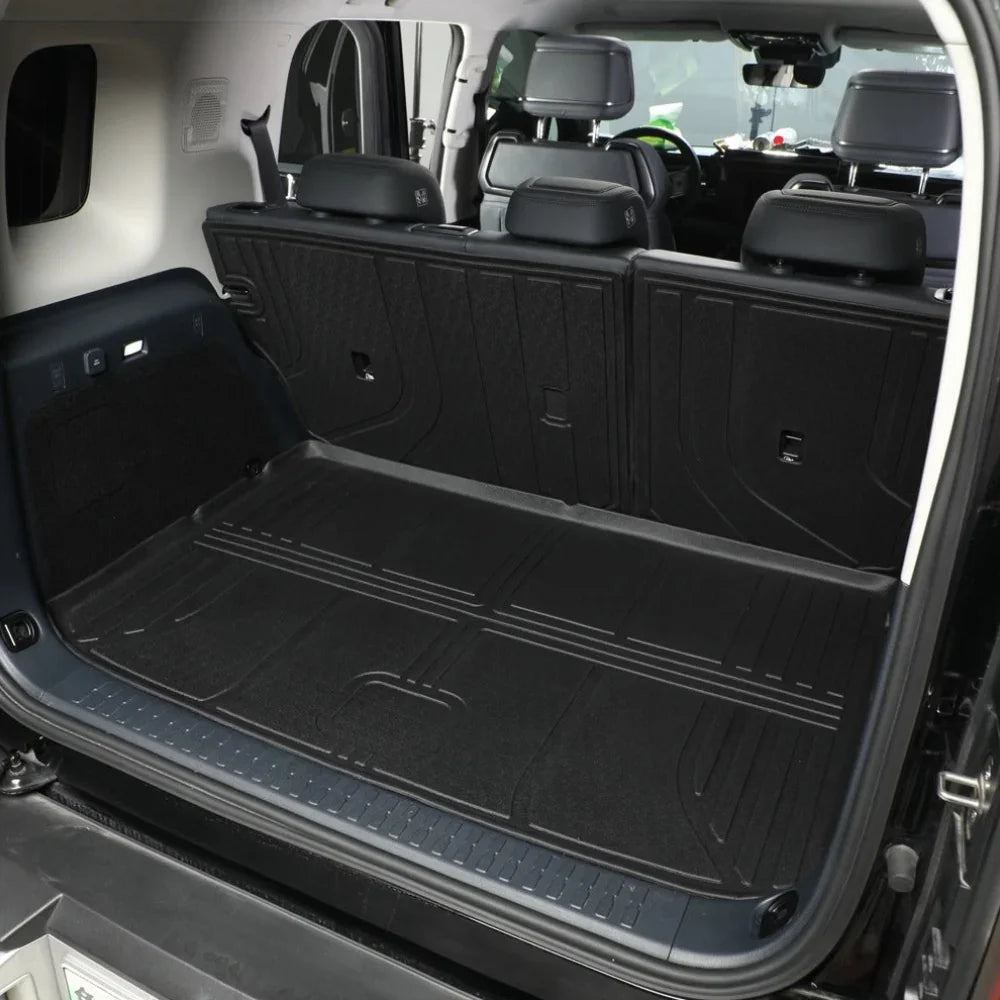 Black heavy-duty rubber cargo mat installed in the trunk of a vehicle for protection.