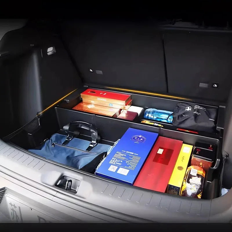 Black custom-fit trunk organizer tray with various items stored in a car cargo area.