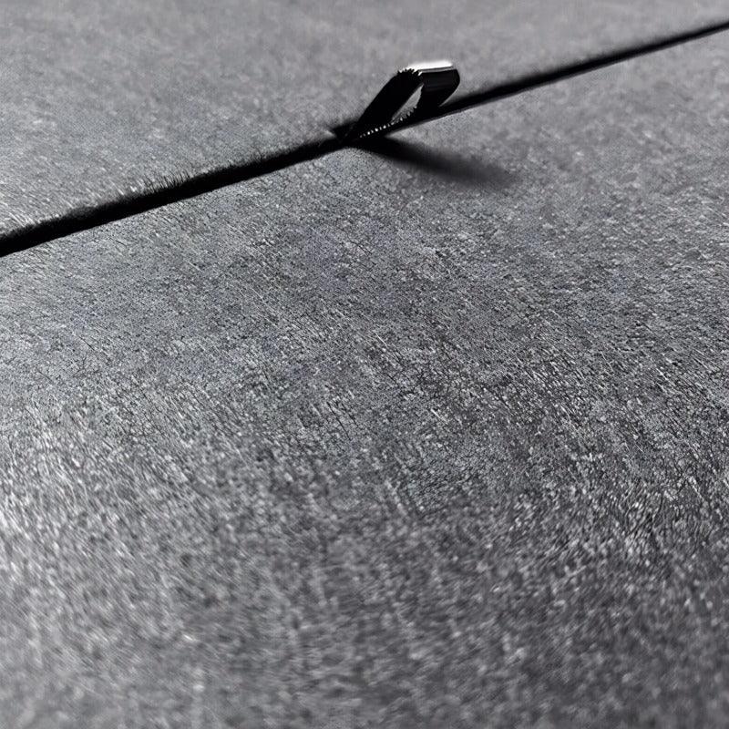 Close-up of a grey textured car accessory material featuring a durable metallic clip.