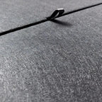 Close-up of a grey textured car accessory material featuring a durable metallic clip.