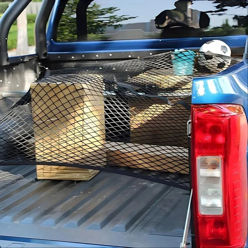 Black heavy-duty mesh cargo net securing cardboard boxes in a blue truck bed.