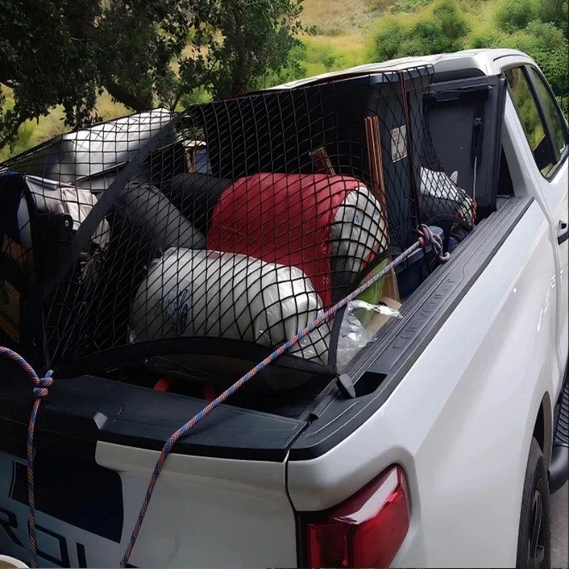 White pickup truck bed secured with a black heavy-duty cargo net holding large gas canisters.