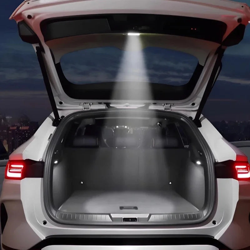 Bright LED trunk light illuminating the spacious grey interior cargo area of a white SUV at night.
