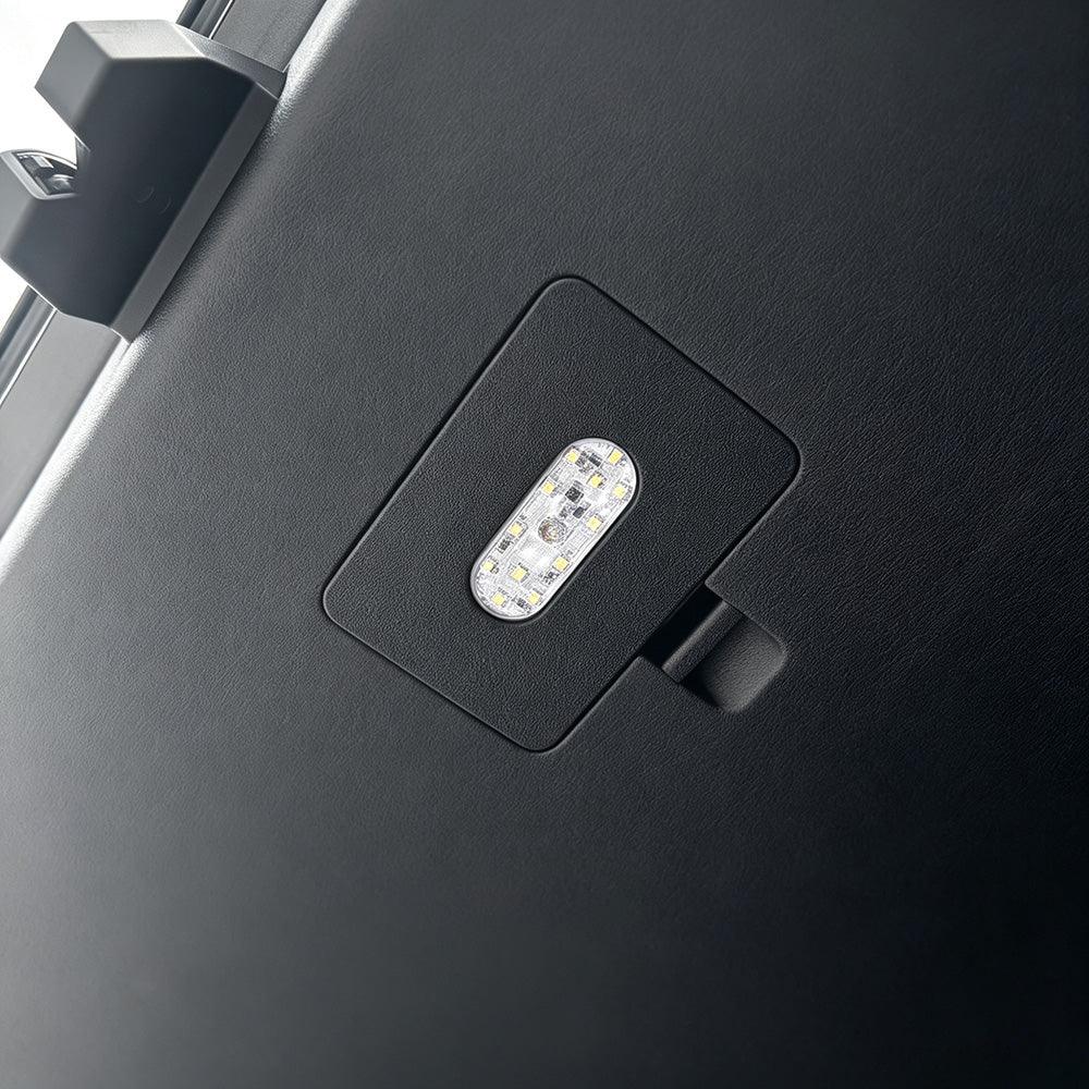 Close-up of a black textured interior trim panel featuring a built-in LED light module.