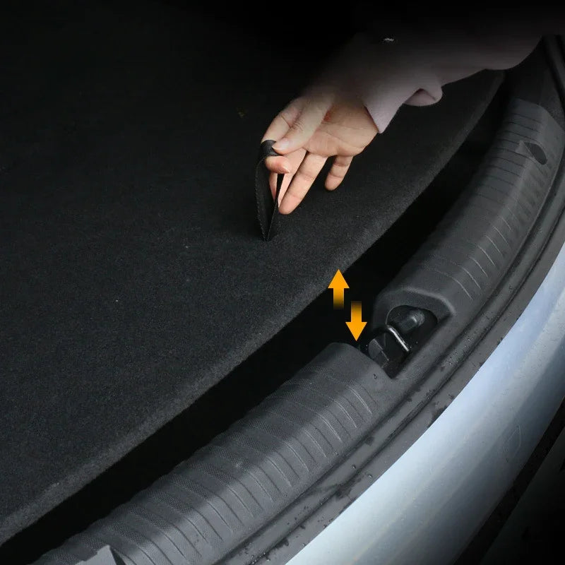 Black heavy-duty fabric trunk mat being easily installed into a car boot using a convenient strap.