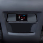 Close-up of a black matte plastic interior car console with a backlit PLUS control button.