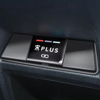 Black glossy plastic interior button panel with white PLUS text and indicator lights