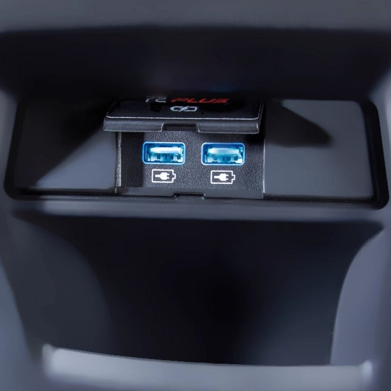 Close-up of two blue USB charging ports in a black plastic car interior console.