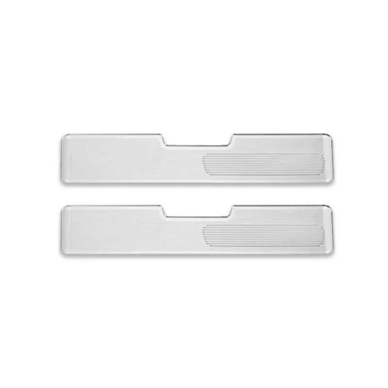 Pair of sleek silver metallic door sill protectors with a ribbed texture design.