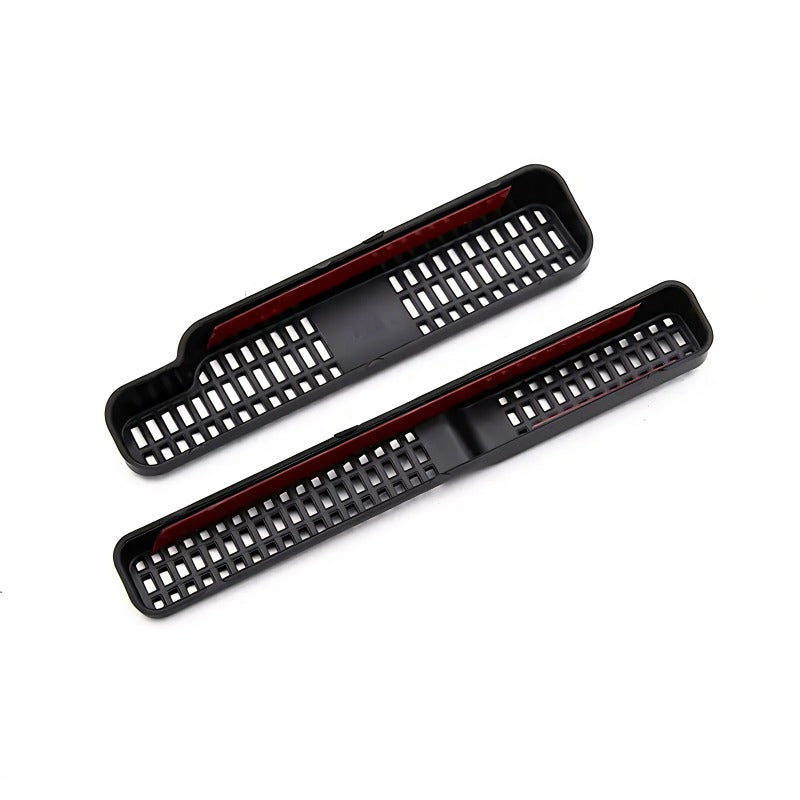 Black textured plastic car interior trim covers with red accent detailing.