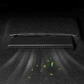 Black plastic under-seat car vacuum cleaner removing debris from a dark grey carpet.