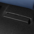 Black textured plastic vent cover integrated into dark grey automotive carpet flooring.