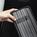 Close-up of a hand touching a black durable ribbed rubber car floor mat with anti-slip texture.