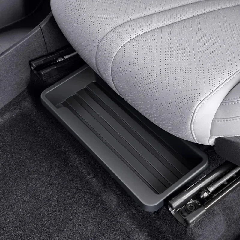 Professional black plastic under-seat storage organizer tray for car interior.