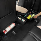 Black leather car seat back organizer with storage bins holding wipes and bottles.