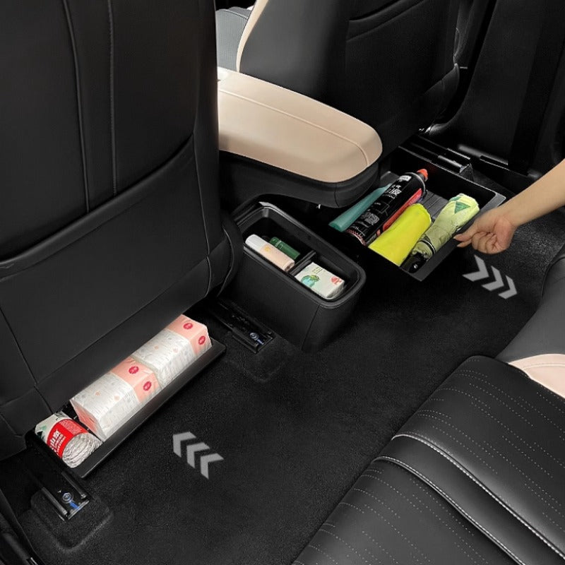 Black leather car seat back organizer with storage bins holding wipes and bottles.