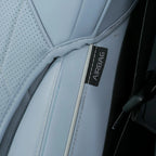 Close-up of a light blue leather car seat with a visible AIRBAG tag and precise stitching.