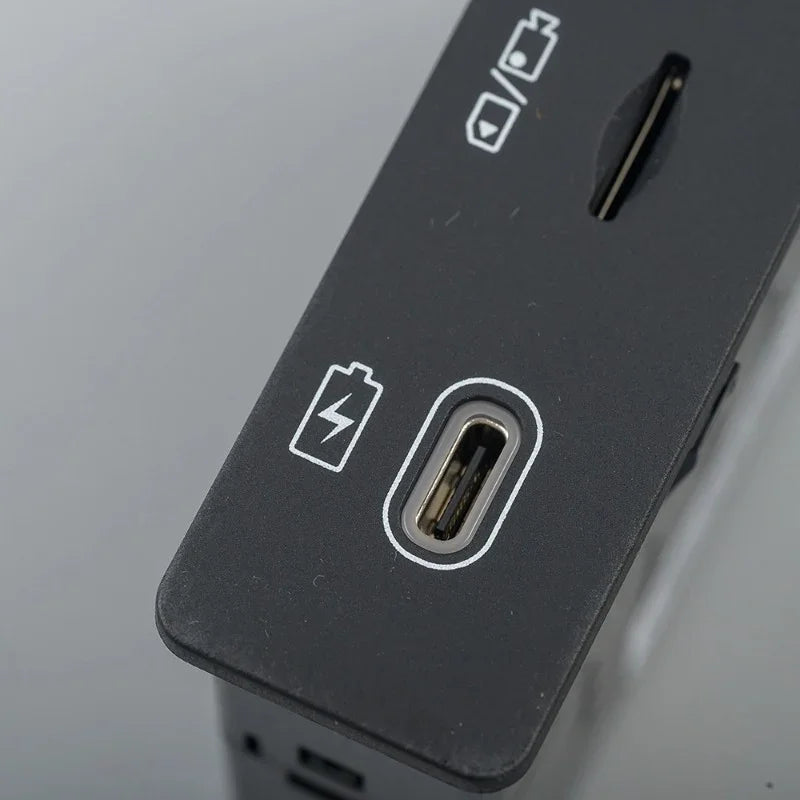 Close-up of a matte black electronic device featuring a USB-C charging port and battery icon.