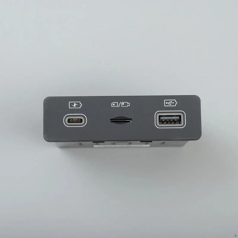Dark grey electronic device featuring USB-C and USB-A ports with a central switch.