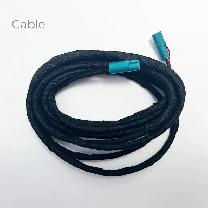 Coiled black fabric-wrapped electrical cable with teal blue connectors
