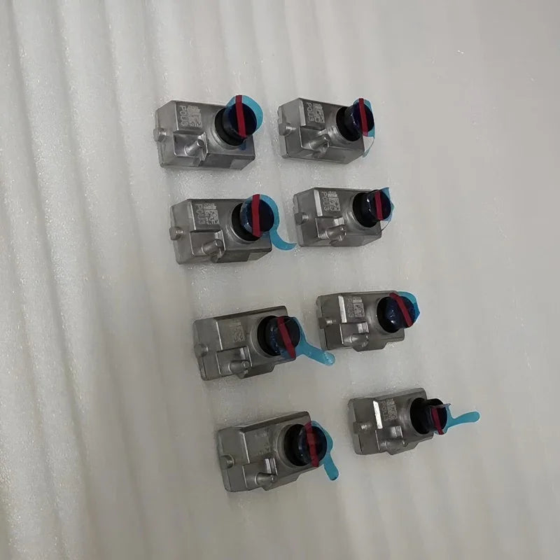 Set of 8 silver metallic automotive valves with blue protective caps and red ring accents.