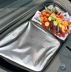 Silver insulated thermal car trunk organizer bag filled with fresh colorful fruits and drinks.