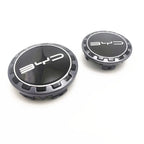 Two black and silver BYD logo valve stem caps with a sleek metallic finish.