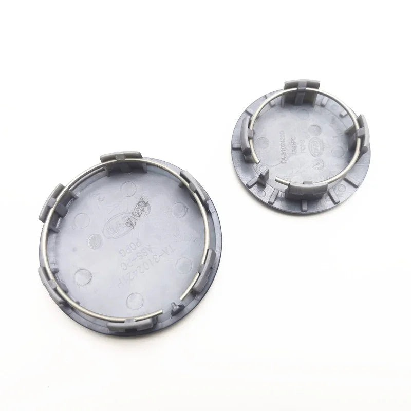 Grey plastic circular replacement cap with integrated metal retaining clips.