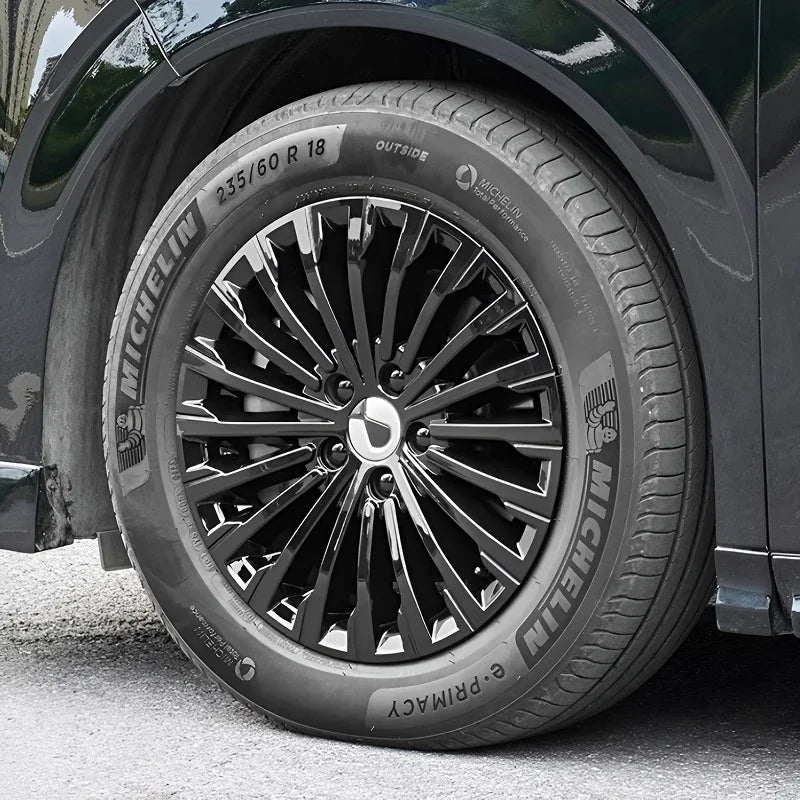 Black multi-spoke alloy wheel with Michelin Primacy tire on a dark vehicle.
