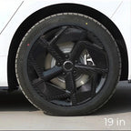 A 19-inch black multi-spoke alloy wheel with a textured geometric design on a white car.