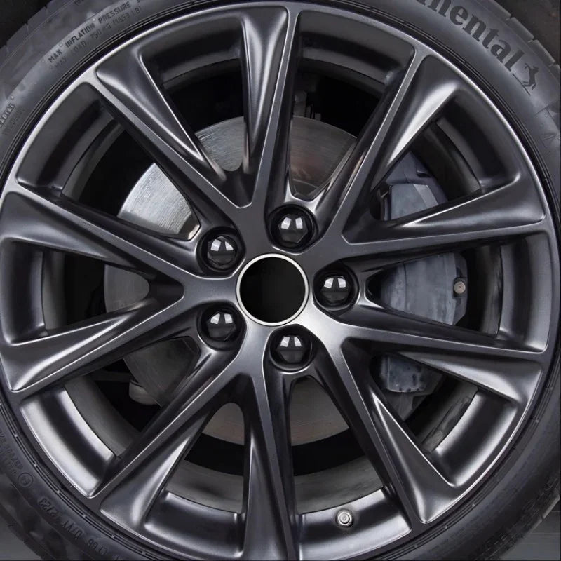 Close-up of a sleek black multi-spoke alloy car wheel with a metallic finish.