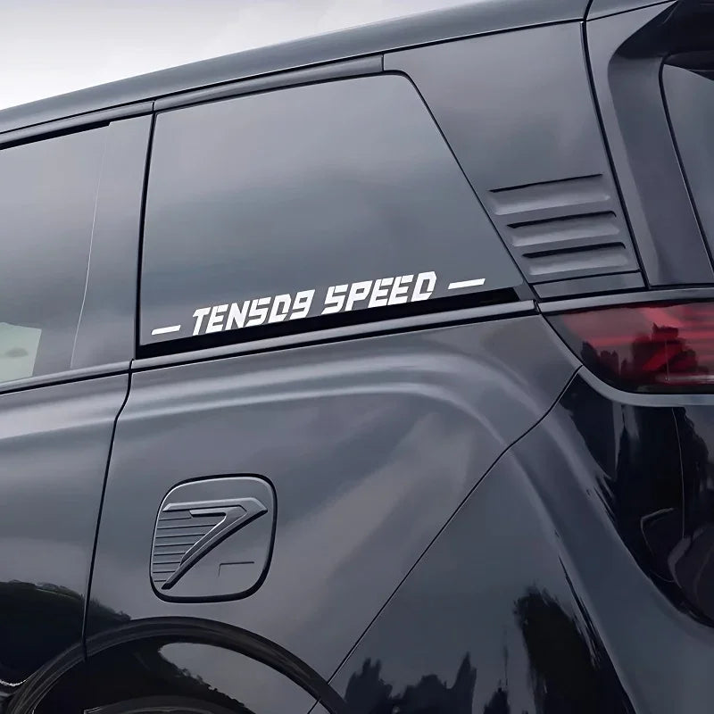 White TENS09 SPEED decal sticker applied to the dark tinted rear window of a black vehicle.