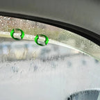 Water-repellent clear glass coating with green recycling icons on a wet car window.