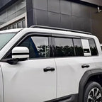 White SUV featuring sleek black window visors and protective roof rails for enhanced durability.