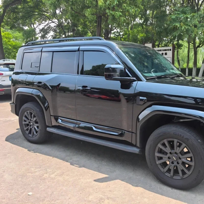 Glossy black luxury SUV featuring tinted windows, roof rails, and rugged matte grey alloy wheels.