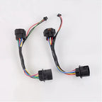 Pair of black automotive electrical wiring harnesses with multi-colored insulated wires.
