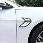 Sleek black chrome side fender vent accessory installed on a white car body.