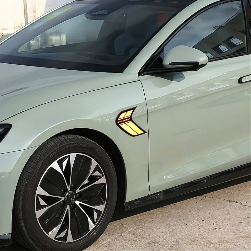 Side view of a light green BYD car featuring a yellow and black decorative fender decal.