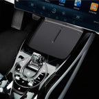 Glossy black carbon fiber texture center console with chrome gear shifter and control buttons.