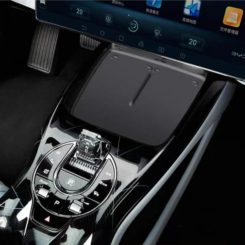 Glossy black carbon fiber texture center console with chrome gear shifter and control buttons.