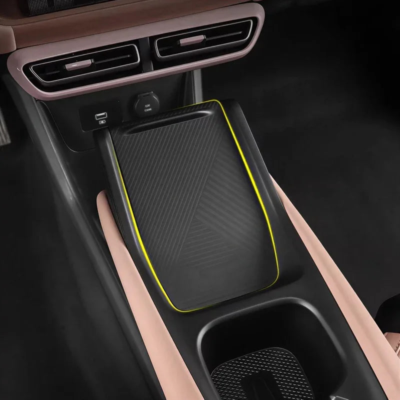 Black textured carbon fiber style center console tray with distinctive yellow edge trim.