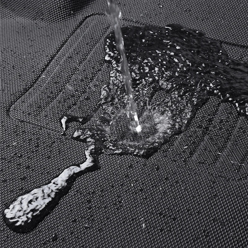 Water splashing on a black waterproof textured car floor mat to demonstrate liquid resistance.