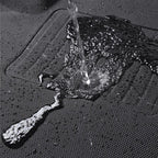 Water repelling black textured waterproof car floor mat showing liquid resistance.
