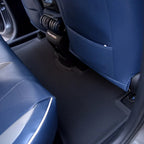 Custom-fit black textured floor mats installed in a car with blue leather seats.