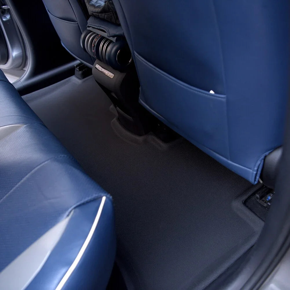Custom-fit black textured floor mats installed in a car with blue leather seats.