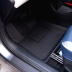 Professional black textured TPE car floor mats with ribbed footrest for interior protection.