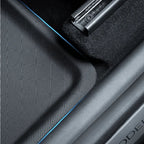 Black textured TPE car floor mat with blue edge stitching for durable interior protection.